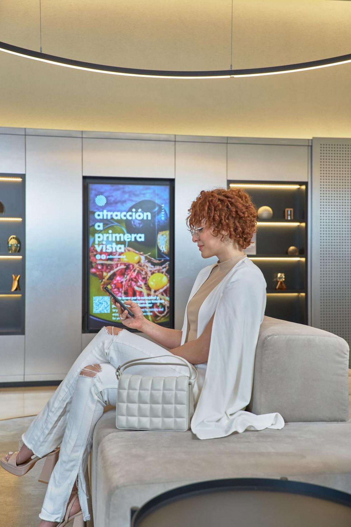 Pullman Santiago Vitacura Екстер'єр фото A woman using a mobile phone to interact with a digital signage display