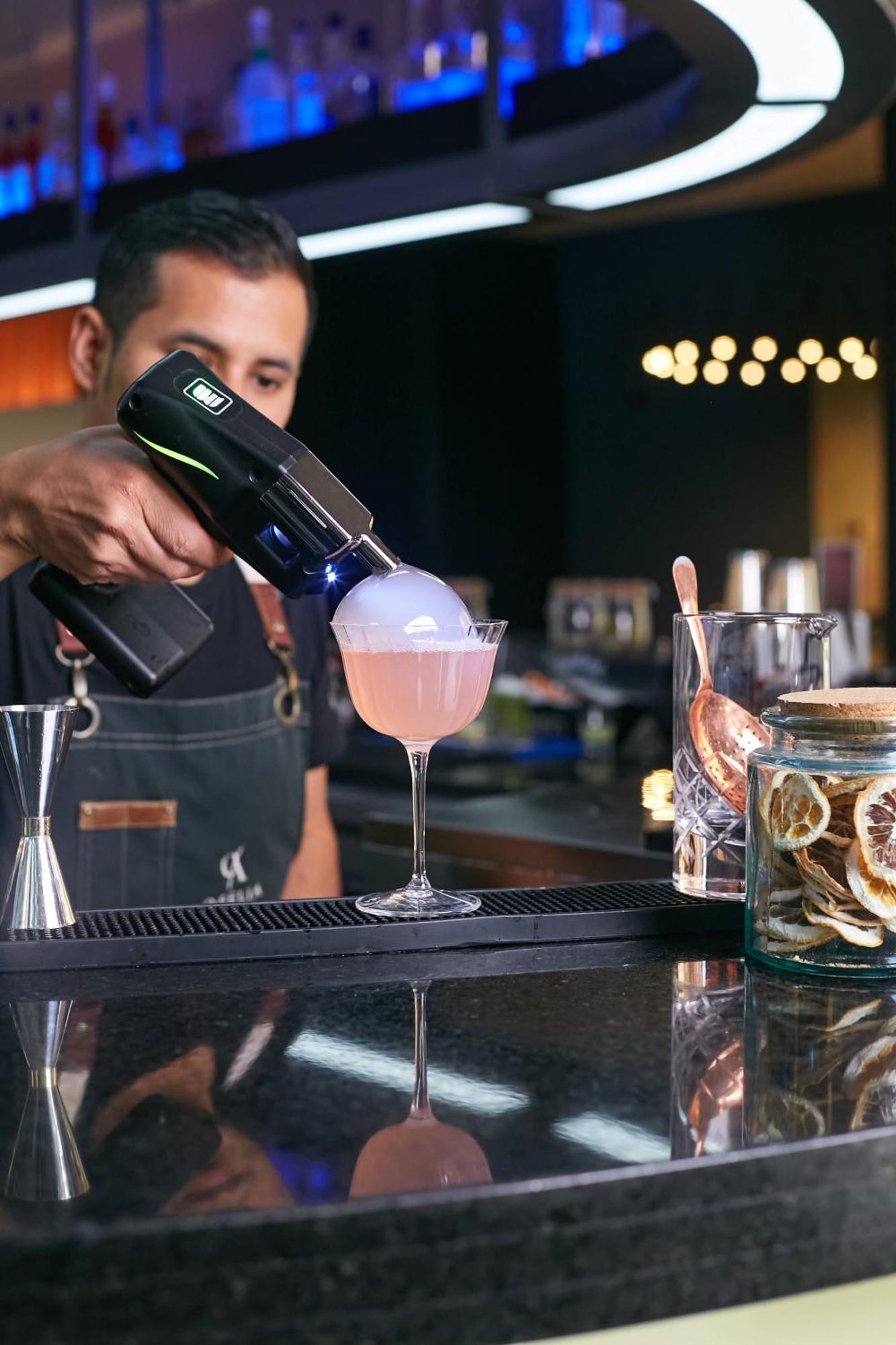 Pullman Santiago Vitacura Екстер'єр фото A bartender using a blowtorch to cook a cocktail